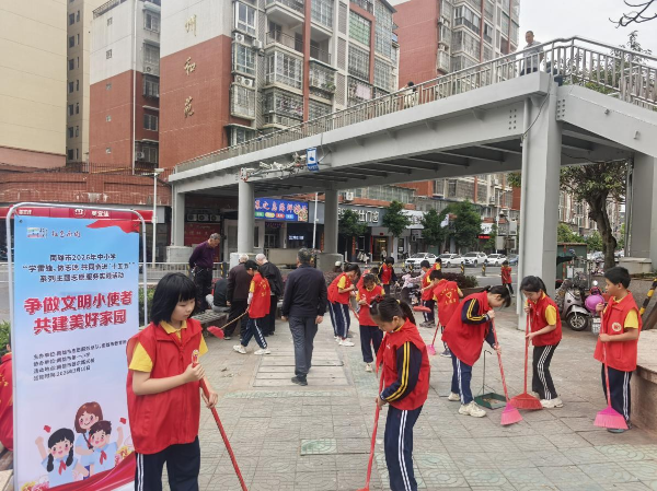 图为南雄市第一小学学生志愿者在学校周边打扫卫生.png