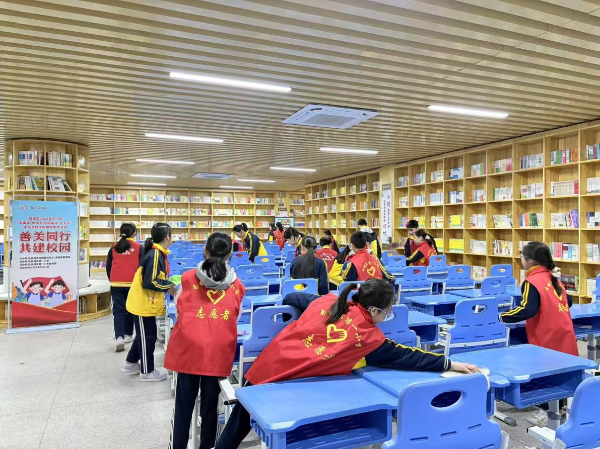 图为南雄市第一小学志愿者整理图书、打扫卫生.png