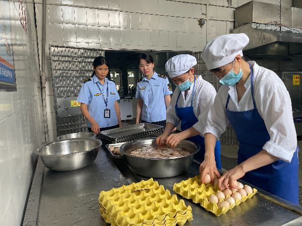 南雄中学考点食堂,执法人员监督鸡蛋清洗(陈小芳 摄).jpg
