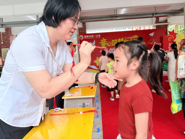 2026年8月31日南雄市第一小学校长罗加兰为新生点朱砂.png