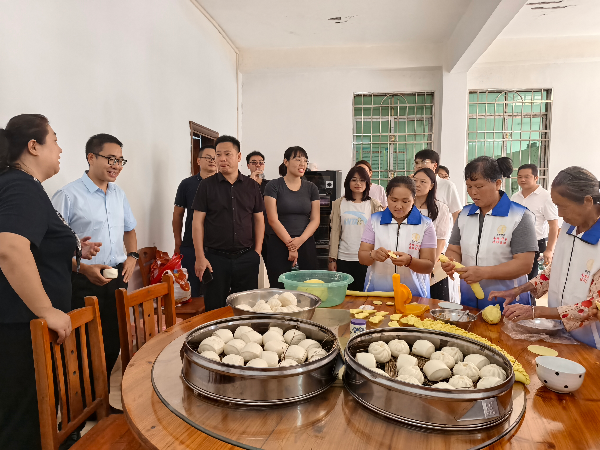 老龙村邻长组织群众包包子、制作饺俚糍.jpg