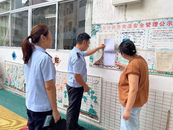 南雄市市场监管局执法人员检查食品安全信息公示情况（陈小芳 摄）.jpg